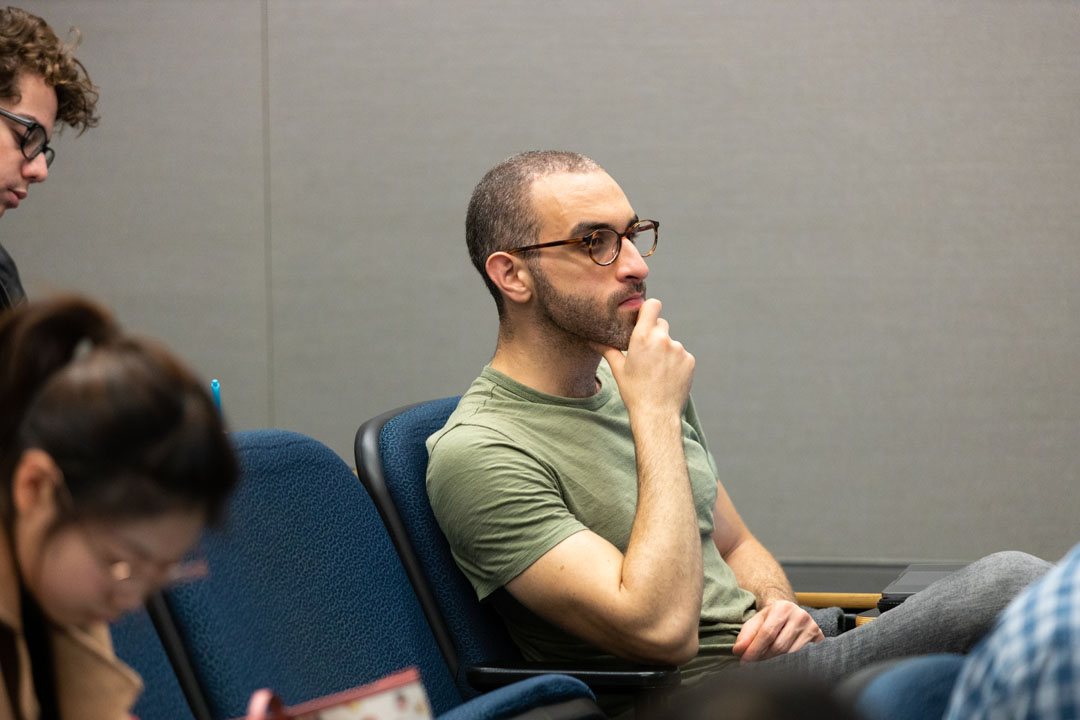 A male student looking attentively in an economics class