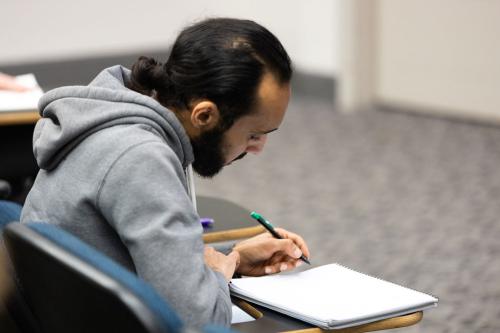 A student writing on a notebook